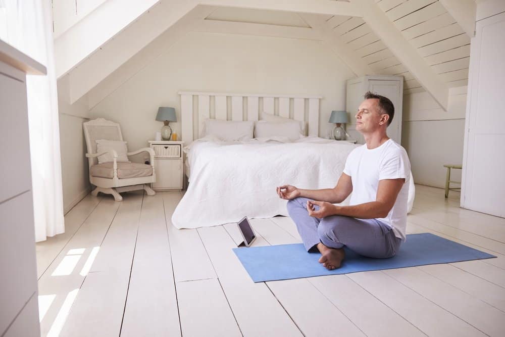 Mature Man With Digital Tablet Using Meditation App In Bedroom - The Metabolic Reset Diet Plan