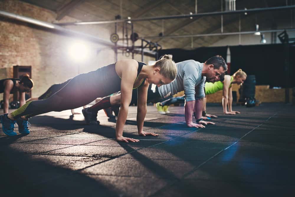 Adults doing push ups as part of Coss-Training Workout - How to Boost Your Body’s Fitness Level and Avoid The Risk of Injury. The Ultimate Guide in Cross-Training.