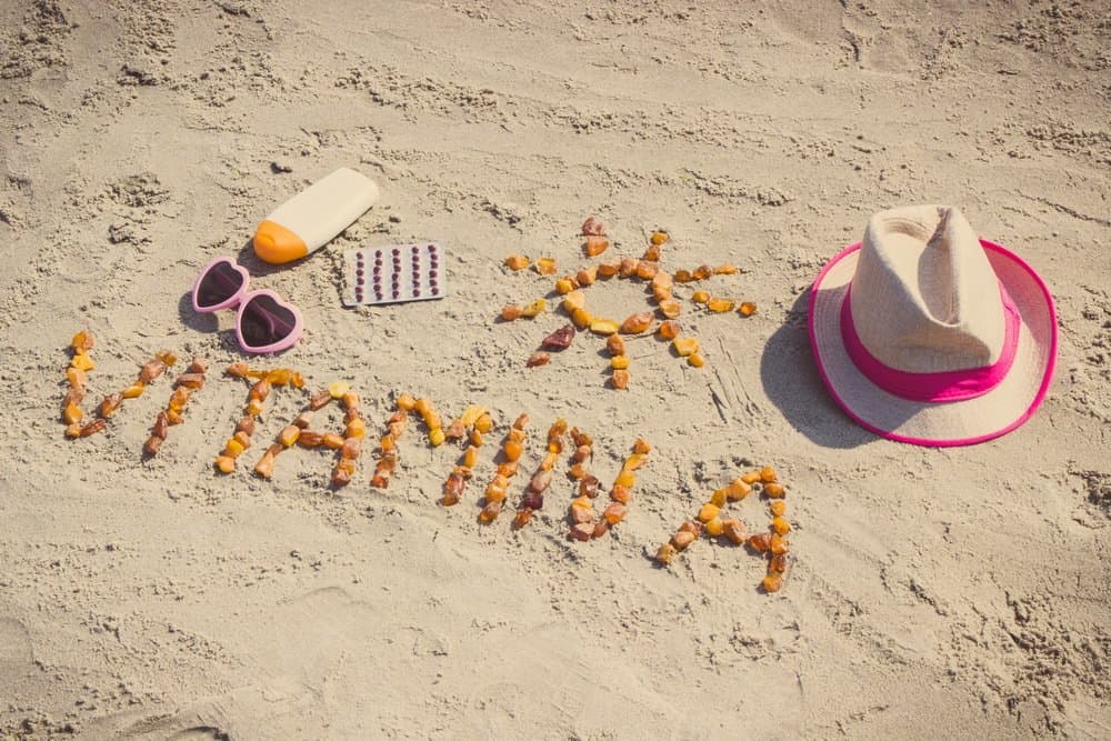 Vintage photo, Medical pills, inscription vitamin A and accessories for sunbathing at beach, concept of beautiful and lasting tan