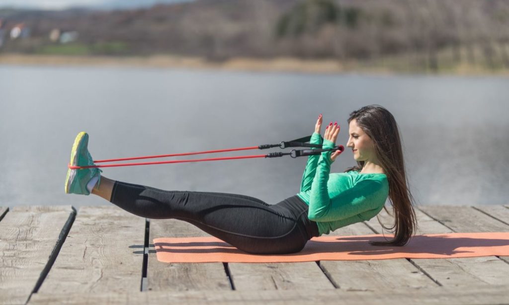 A young girl performing a resistance band workout session