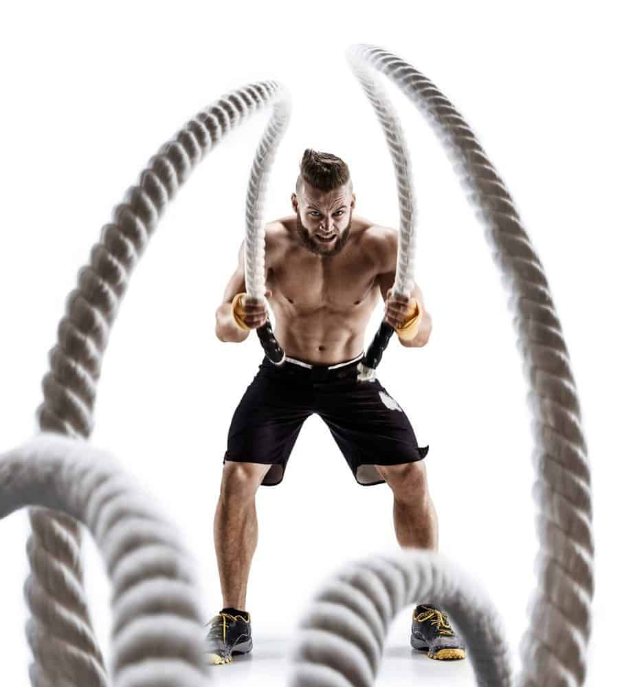 Strength Training Attractive muscular man working out with heavy ropes - 10 Ways to Lose Belly Fat