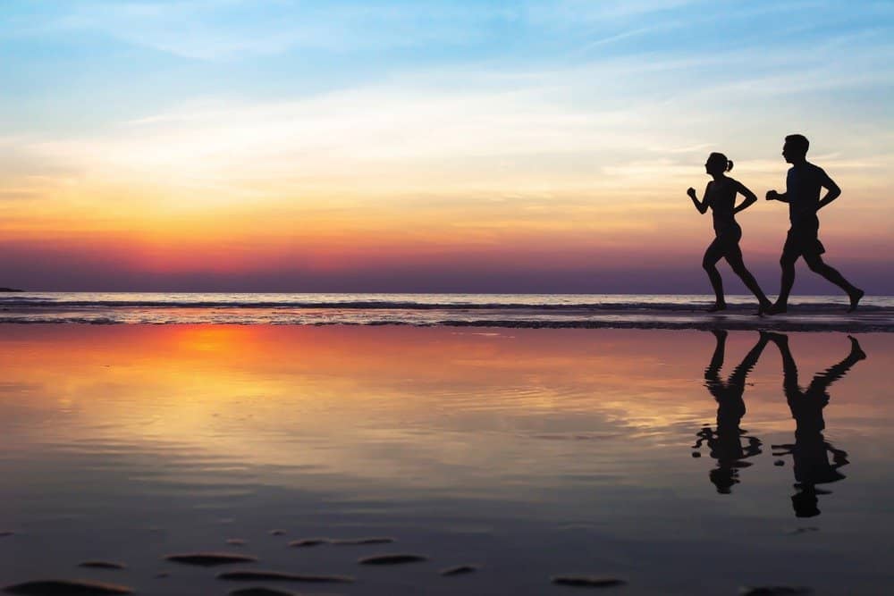 two runners on the beach, silhouette of people jogging at sunset, healthy lifestyle background - How to Motivate Yourself for Workout
