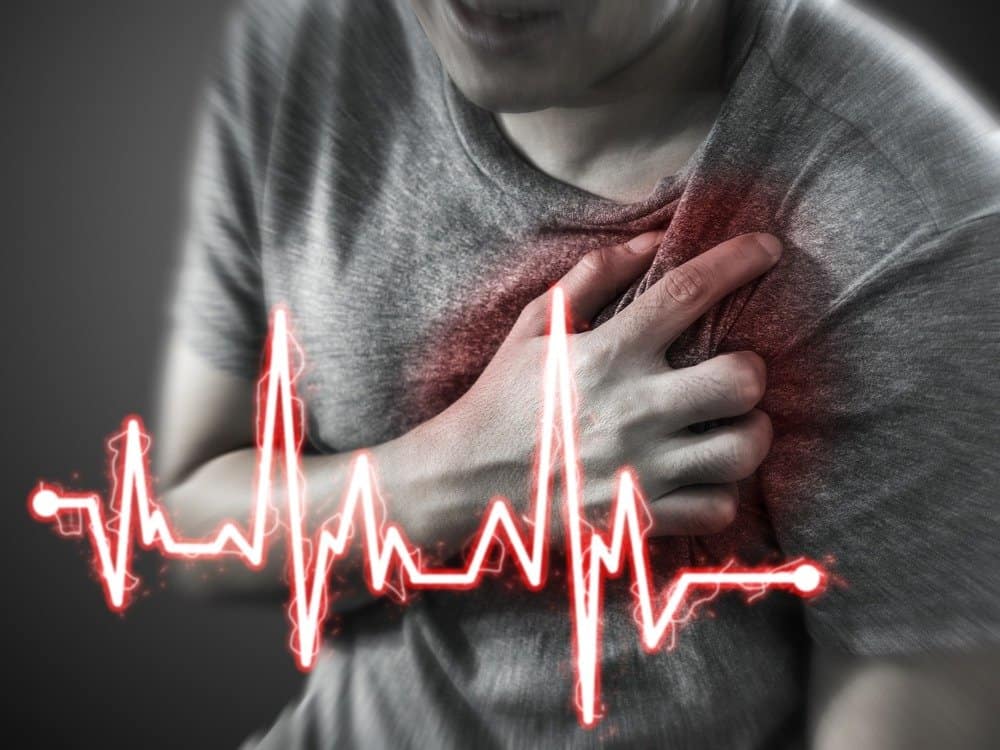 Severe heartache, man suffering from chest pain, having heart attack or painful cramps, pressing on chest with painful expression - Does Exercise Make You Live Longer?
