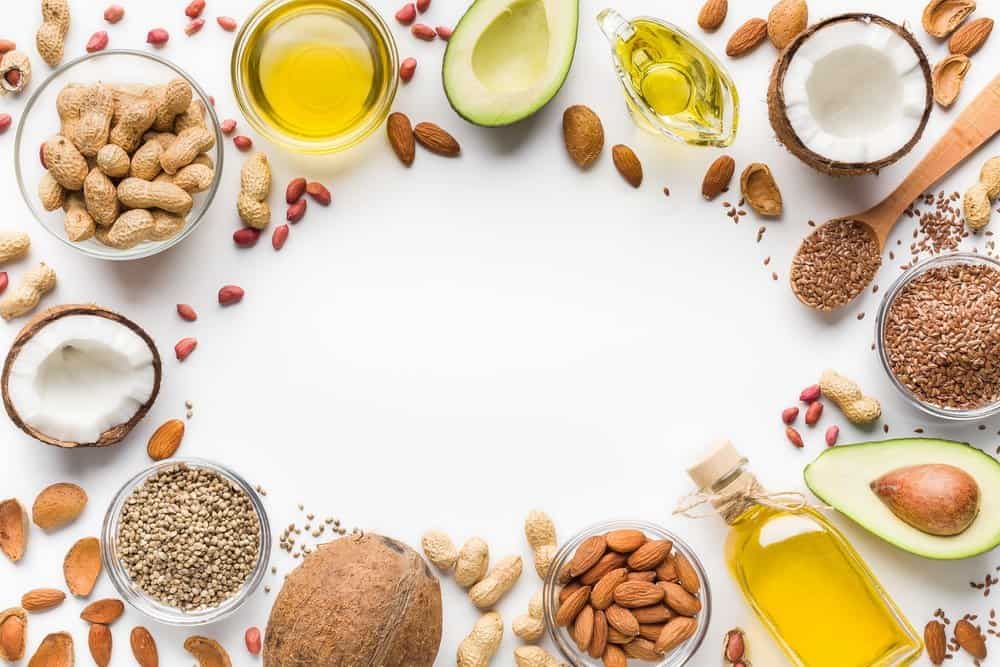 Avocado, coconut, almonds, hemp seeds, linseeds, olives and oils over white background, top view. Alternative oils concept, copy space - Diet Smoothies for Weight Loss