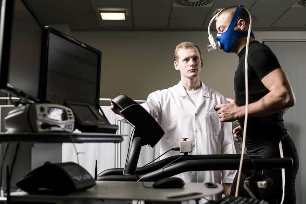 Athletic man running on a treadmill with the doctor monitoring him - Side Effects from Keto Diet