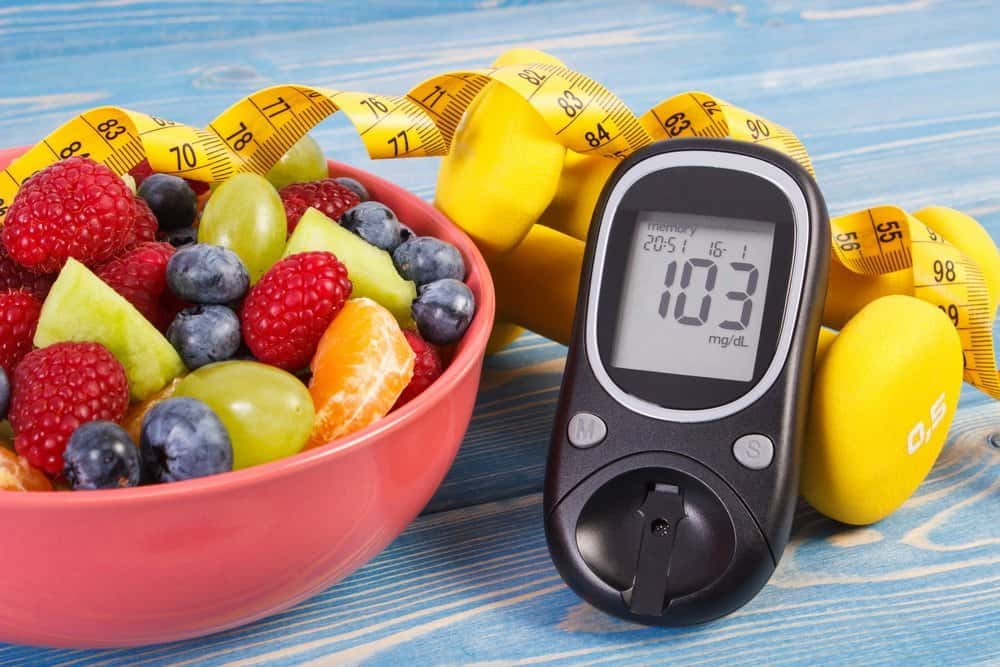 Fresh salad, glucose meter with result of sugar level, tape measure and dumbbells for fitness, concept of diabetes, slimming, healthy lifestyles and nutrition