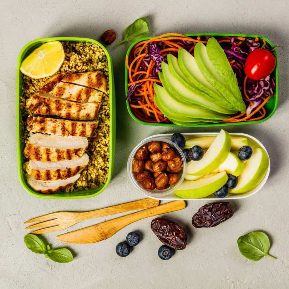 Tips on Lose Weight Quickly - Healthy meal prep containers: Couscous with grilled chicken breast, salad, avocado, berry, apple, nuts and dry dates. Keto, ketogenic diet, low carb, healthy food concept. Top view