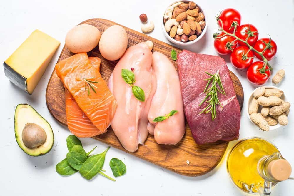 Tips on Lose Weight Quickly - Ketogenic low carbs diet. Meat, fish, nuts, oil, cheese and avocado on white background. Top view.