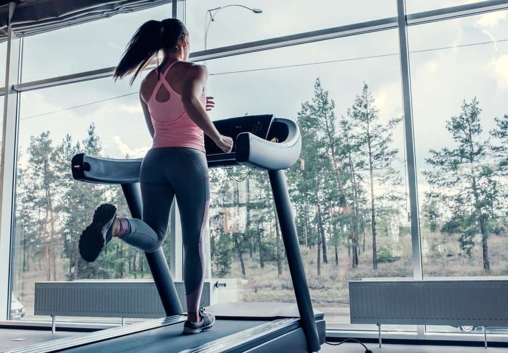 young sports woman is working out in gym - Signs You're Overdoing Cardio