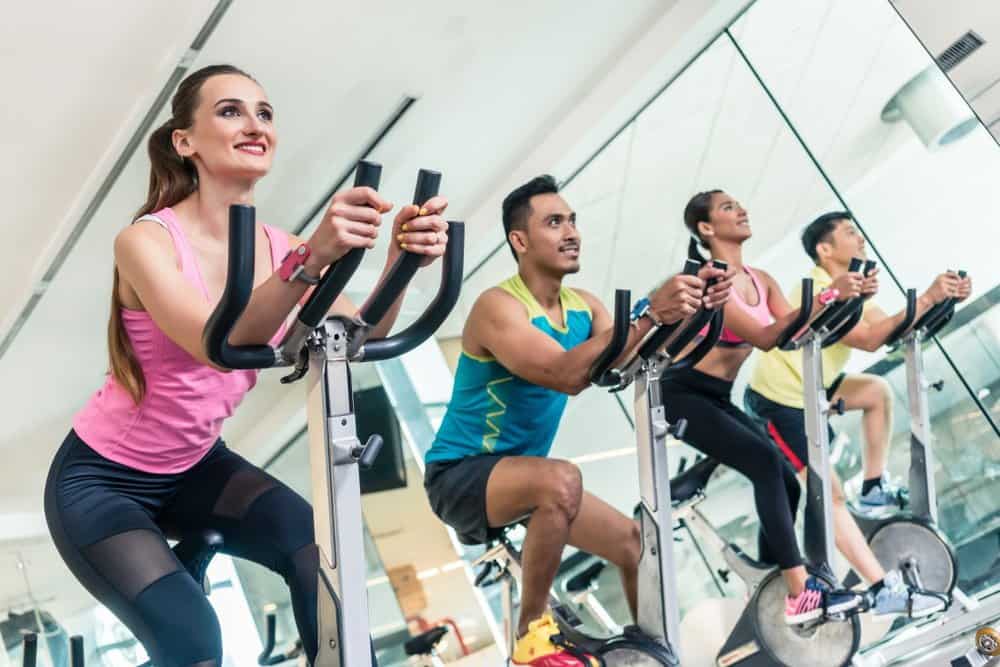 Cardio workout at indoor cycling group - How to Boost Your Body’s Fitness Level and Avoid The Risk of Injury. The Ultimate Guide in Cross-Training.