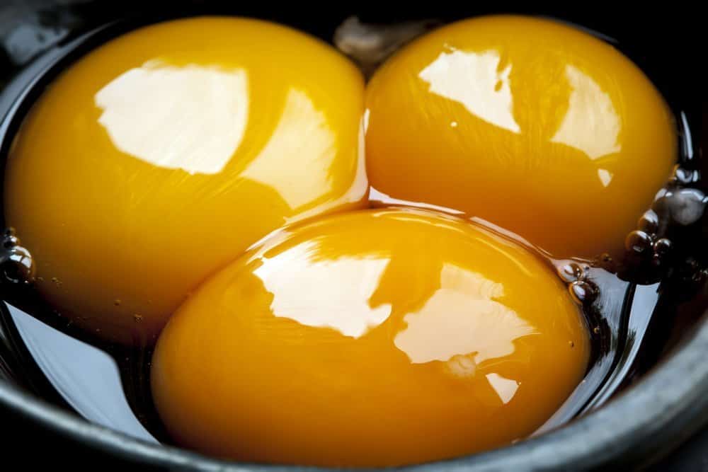 Egg yolks in small black bowl - Can Food Affect Our Mood?