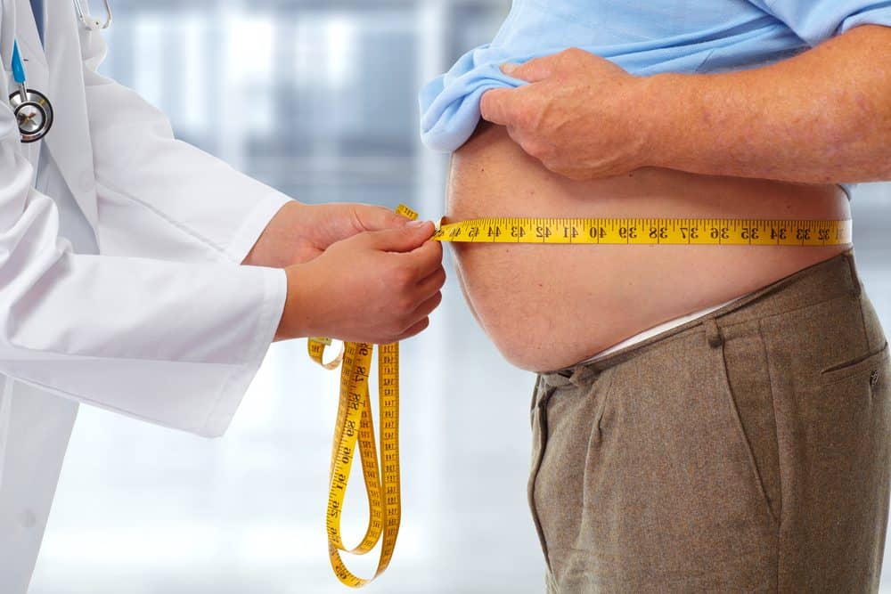 Doctor measuring obese man waist body fat. Obesity and weight loss.