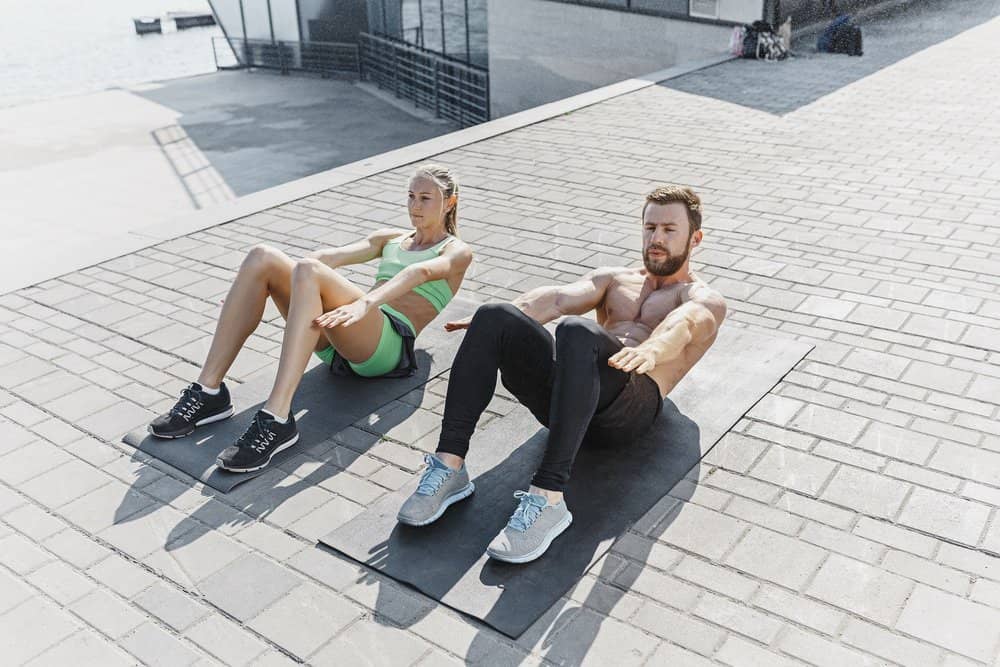 Fit fitness woman and man doing fitness exercises outdoors at city Fit fitness woman and man doing fitness exercises outdoor at city background. the best abdominal muscle press in the world. Female and male sports models exercising in summer at morning. - Amazing Facts About Fitness