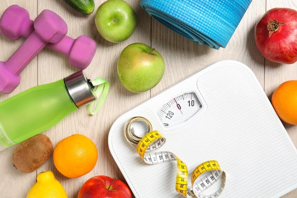 Healthy Lifestyle concept - Healthy food, sport equipment on wooden background. Weight loss - Ideal Body Weight (IBW) Calculator