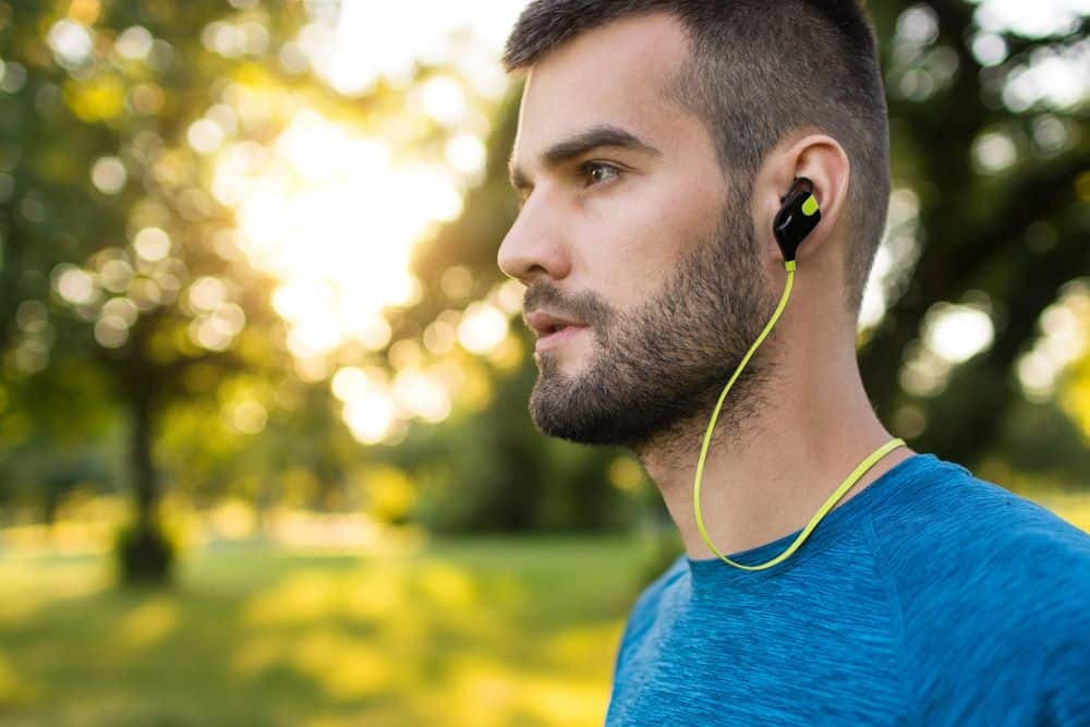 Closeup of a young runner wearing wireless headphones - Running Gear for Beginners Closeup of a young runner wearing wireless headphones - Running Gear for Beginners