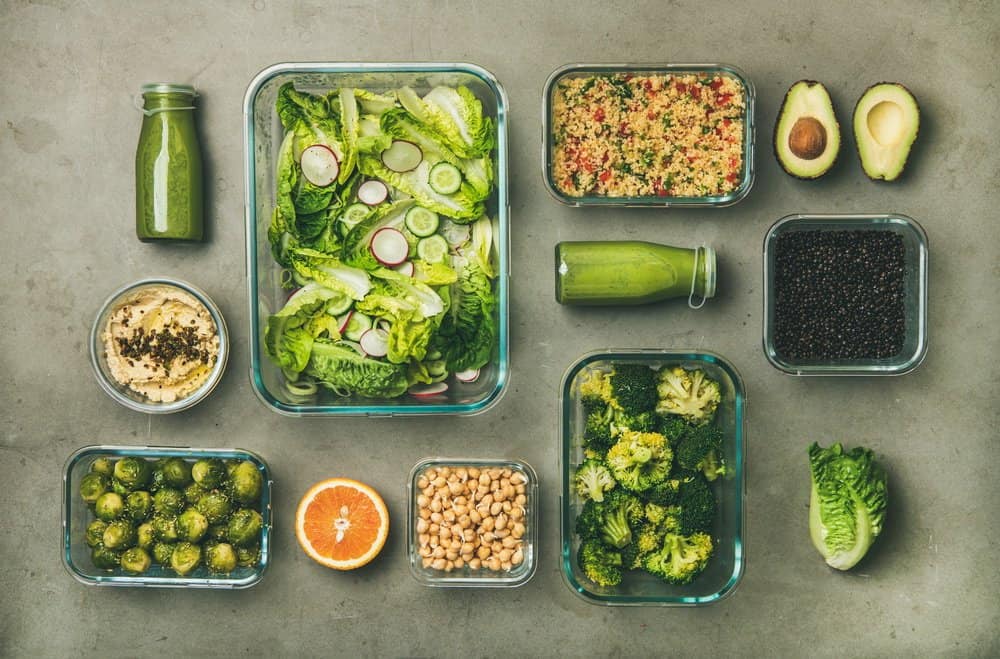 Healthy vegan dishes and drinks in bottle over concrete table