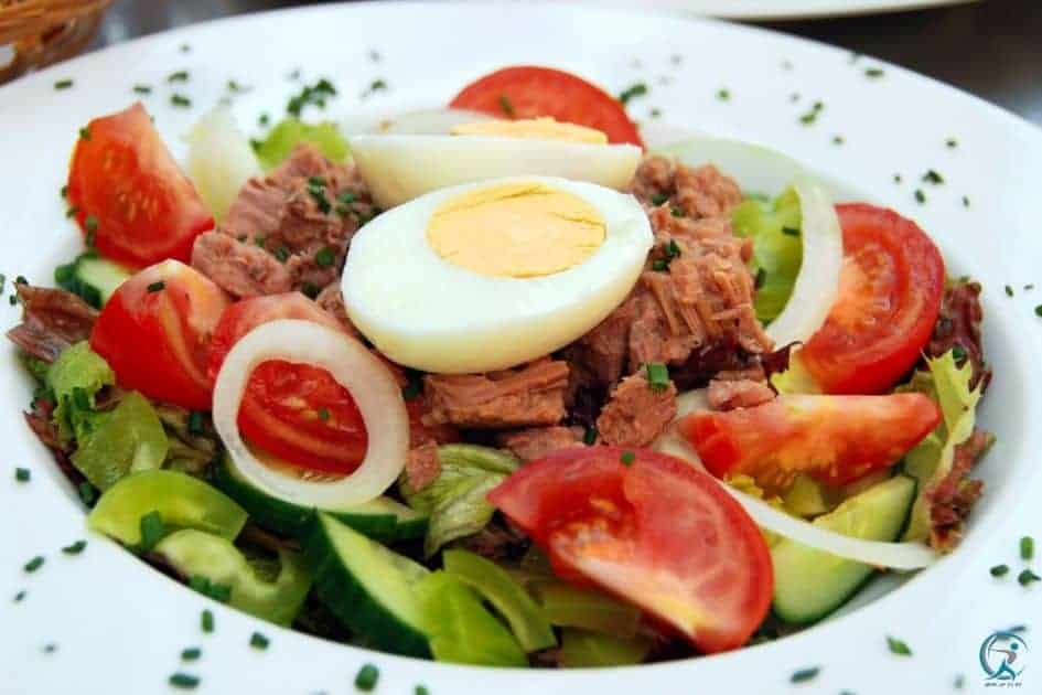Tuna salad with boiled potatoes, hard-boiled eggs, onions, mayonnaise, and salt