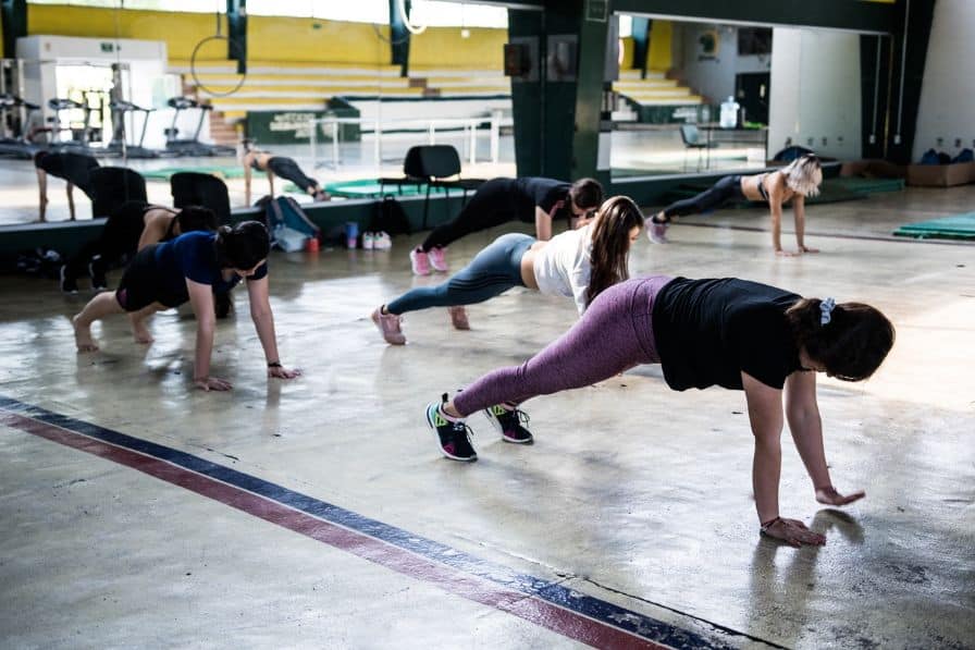 women doing push ups at sports hall