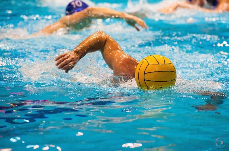Water polo is a team sport in which two teams of seven players try to score goals by throwing the ball into the opposing team's goal.