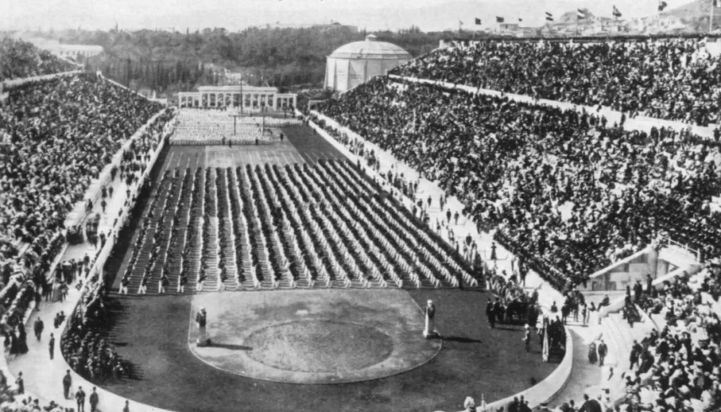 Historical black and white photo of a large gathering during the early Olympic Games, showcasing the popularity and significance of running events in human history.