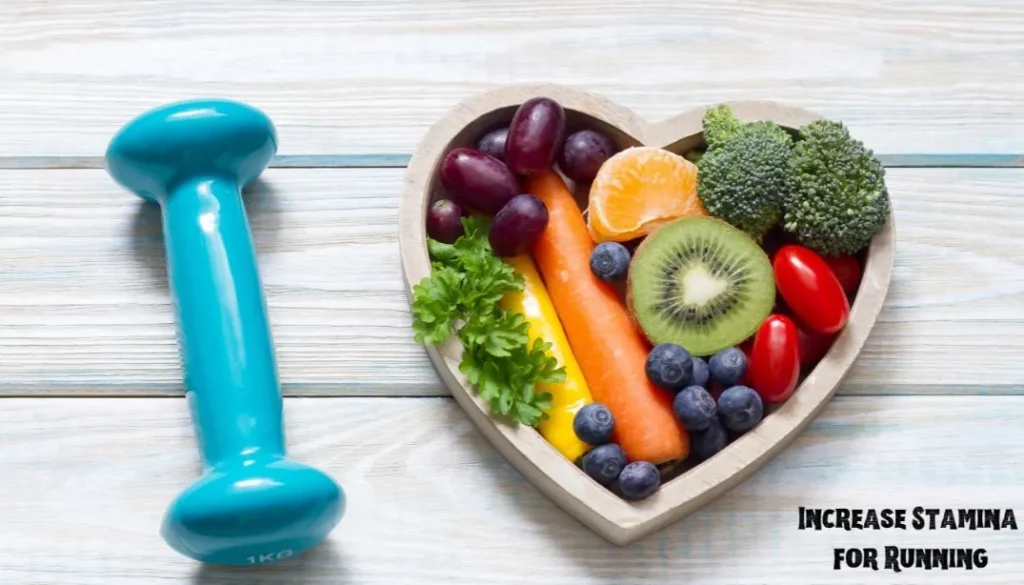 A heart-shaped bowl filled with various healthy foods next to a blue dumbbell, on a wooden surface.
