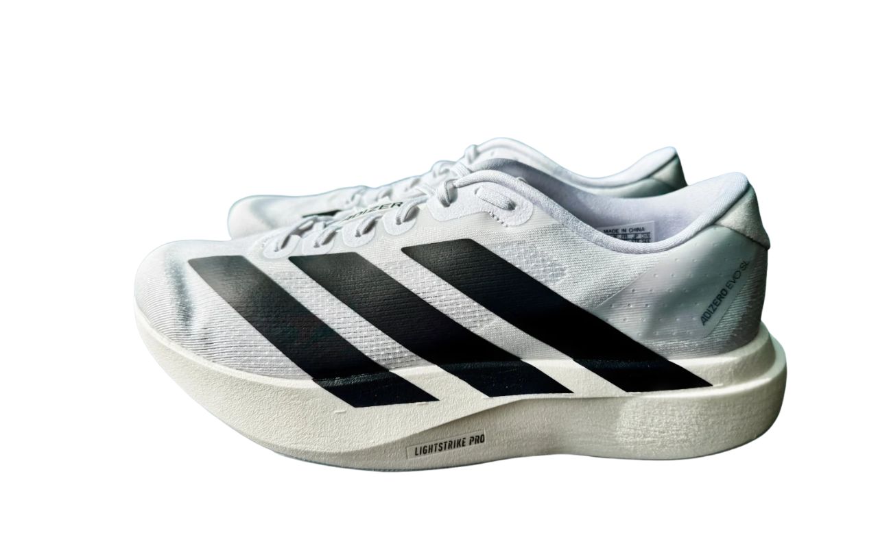 The image shows a pair of white Adidas Adizero Evo SL Lightstrike Pro running shoes, with the left shoe prominently...