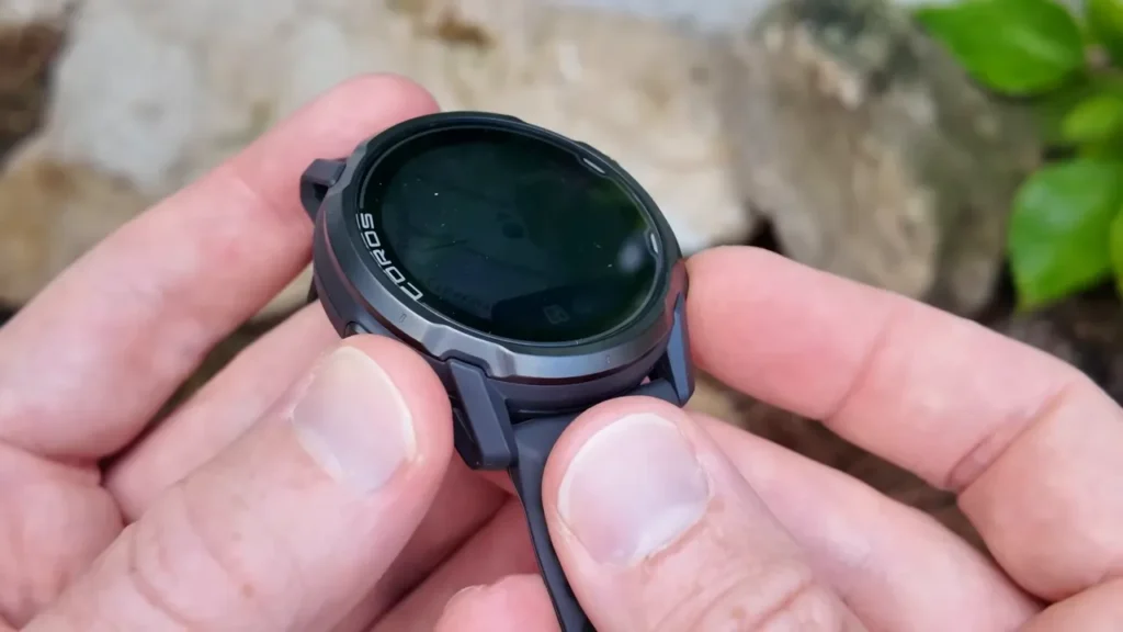 COROS APEX 4 smartwatch on a runners wrist with a scenic trail background.