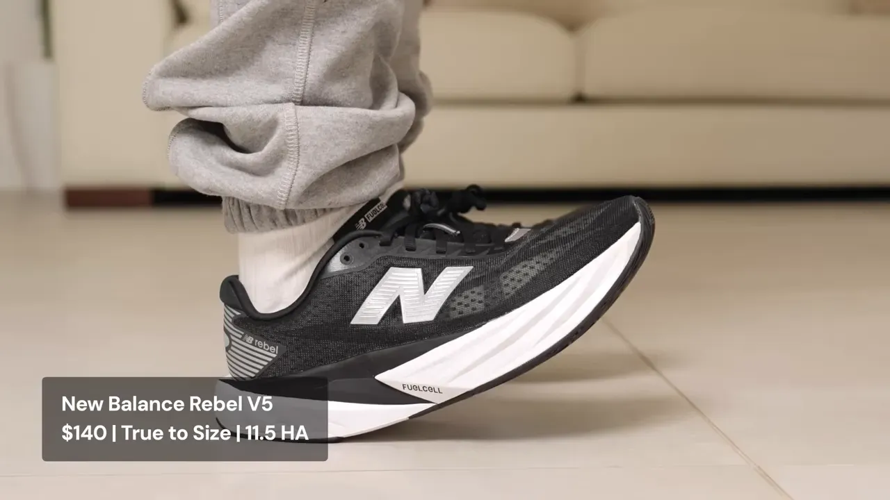 Person wearing a black New Balance Rebel V5 running shoe with a white sole and silver logo.